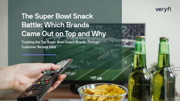 Person holding remote, watching football on TV and eating snacks